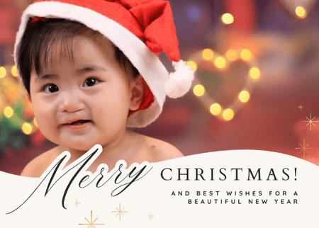 A baby with cleft needs is wearing a Santa hat. The foreground reads "Merry Christmas! and best wishes for a beautiful New Year"